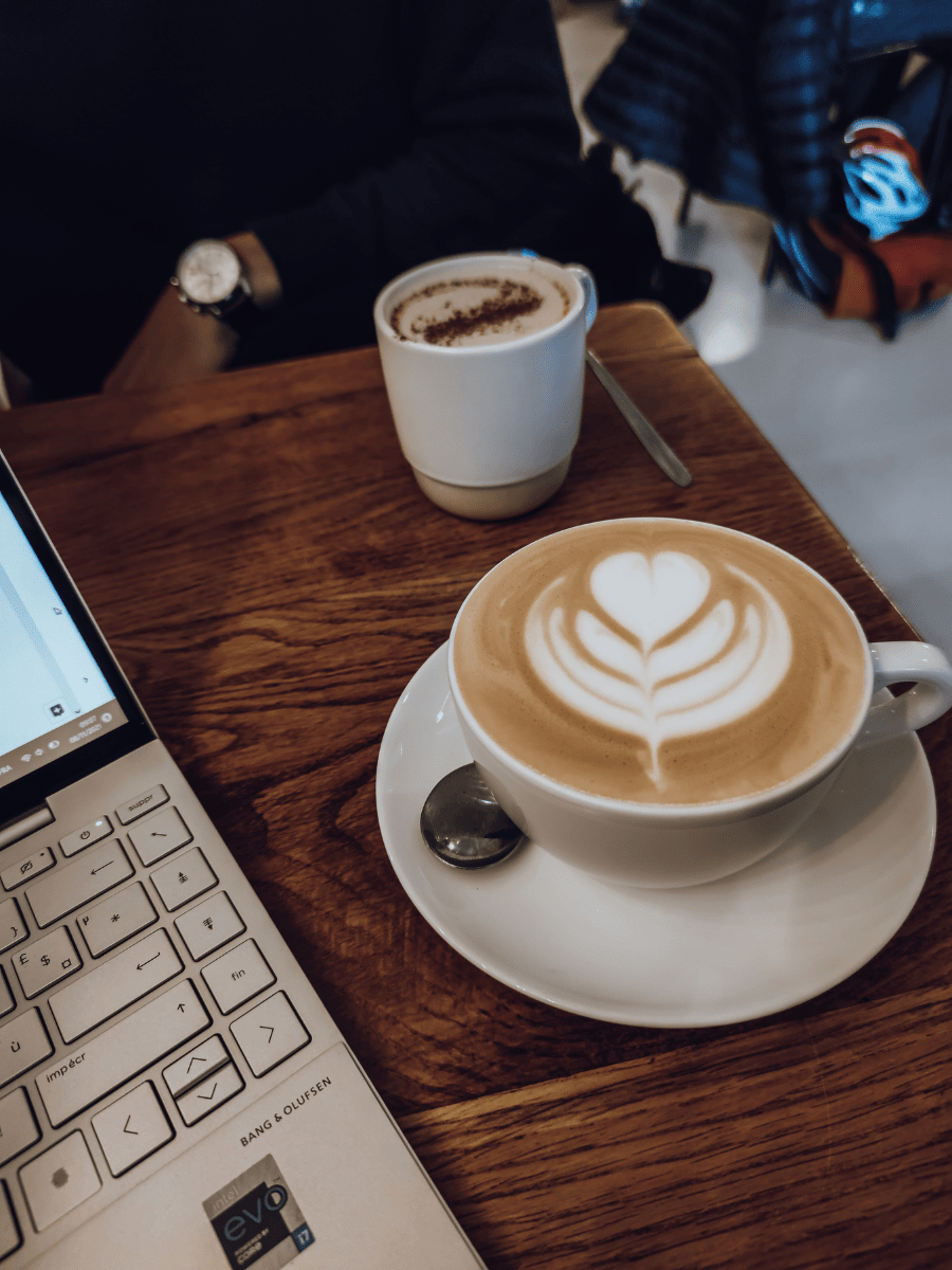Tasse de café posée à côté d’un ordinateur